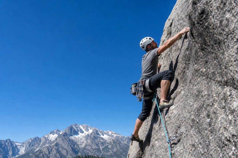 Rock climber wearing a climbing harness on an outdoor crag