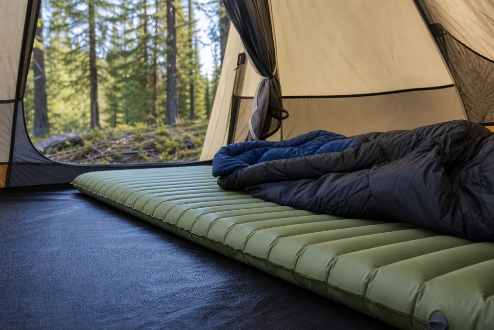 Ground mat and sleeping pad setup at a campsite